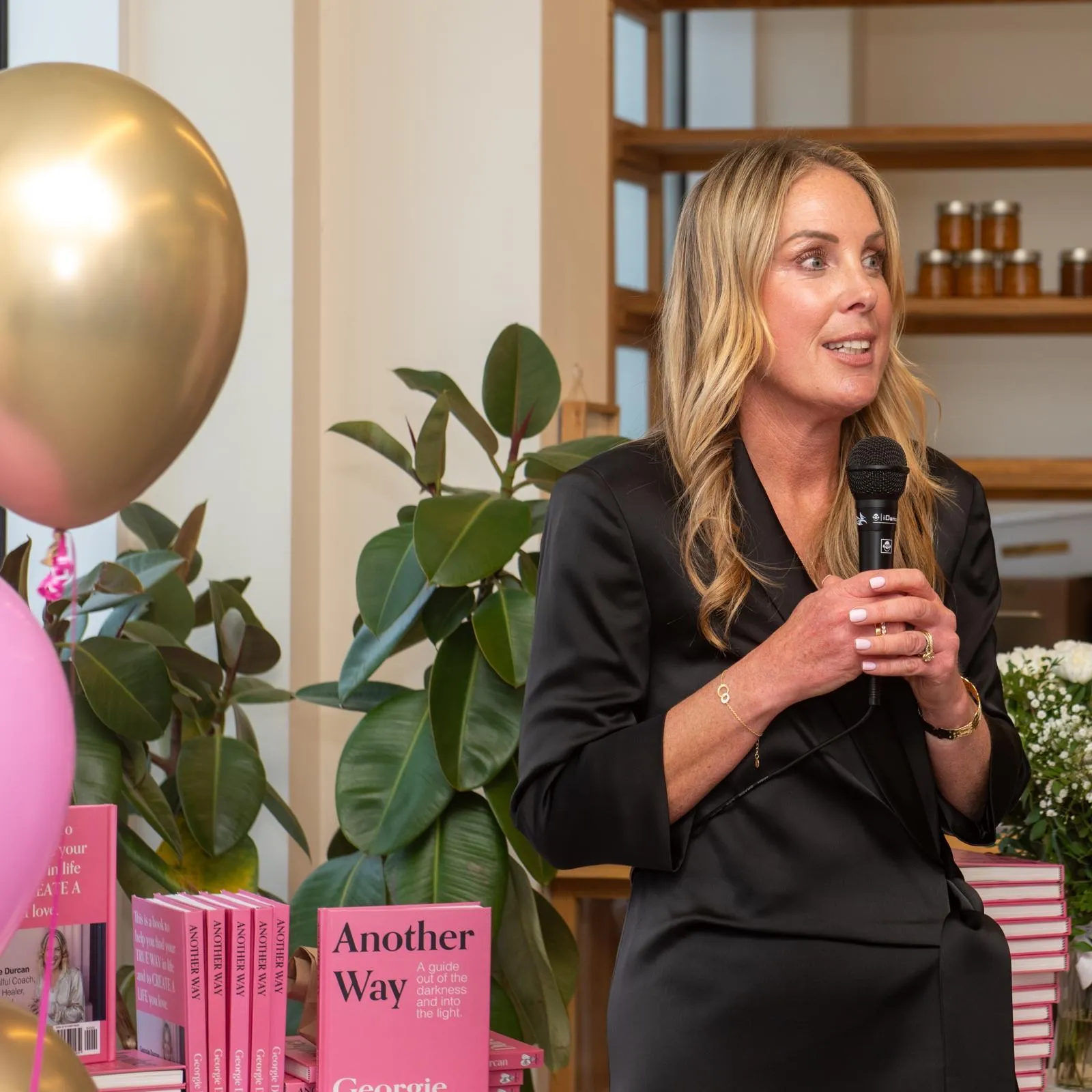 Georgie Durcan speaking at a book event, copies of Another Way on the table